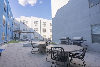 A patio with tables and chairs in a courtyard